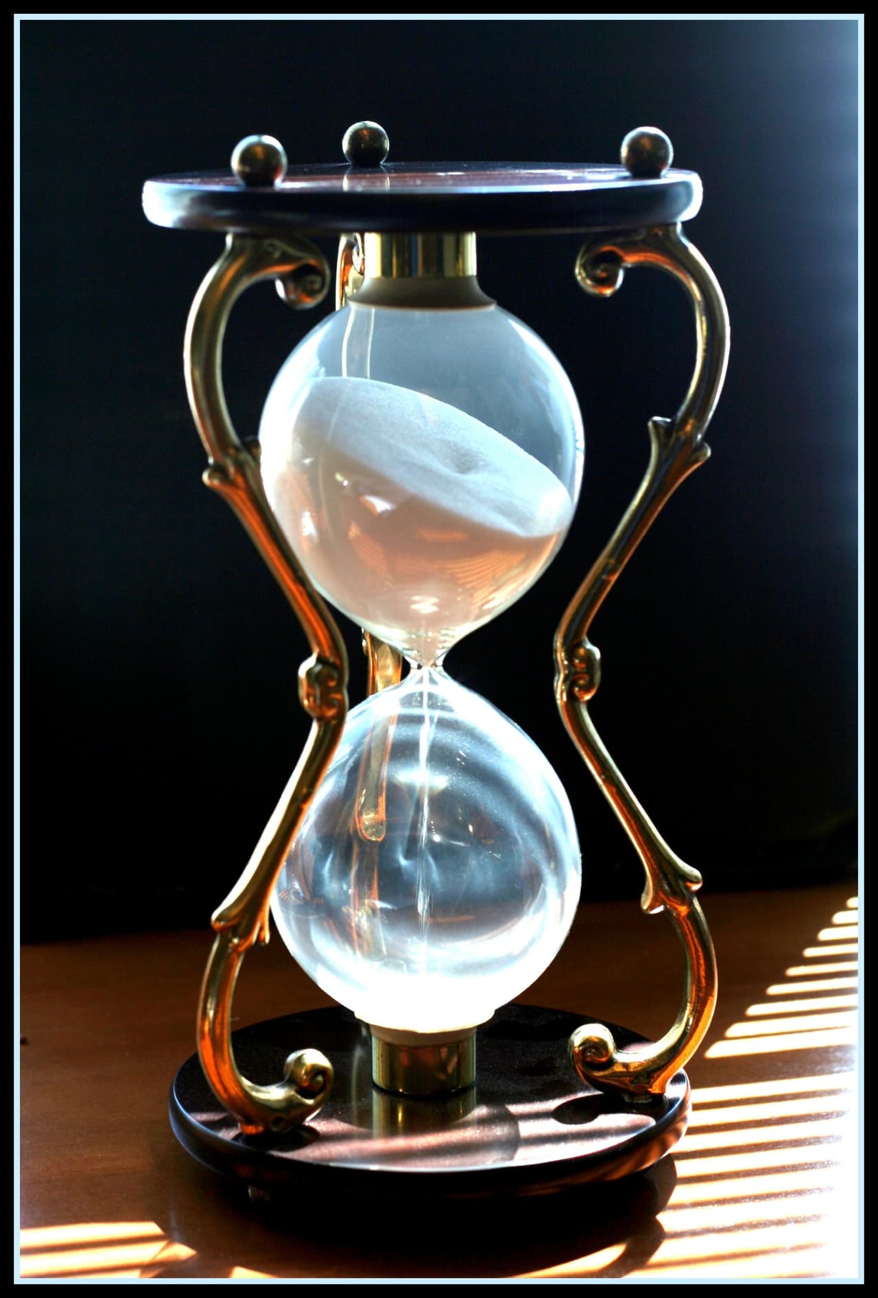 An hourglass with running sand, illustrating the epoch-length waiting period when unstaking SOL